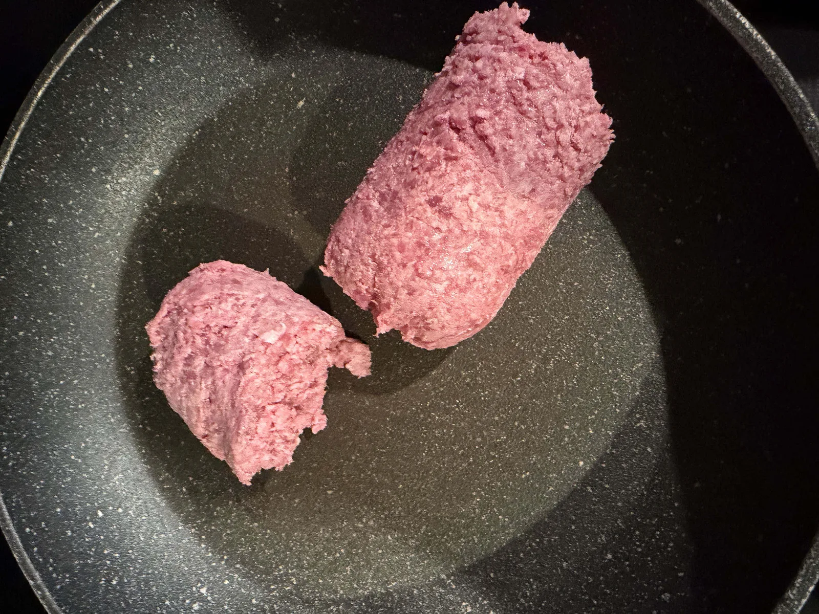 Ground beef starting to cook in a skillet before being broken up