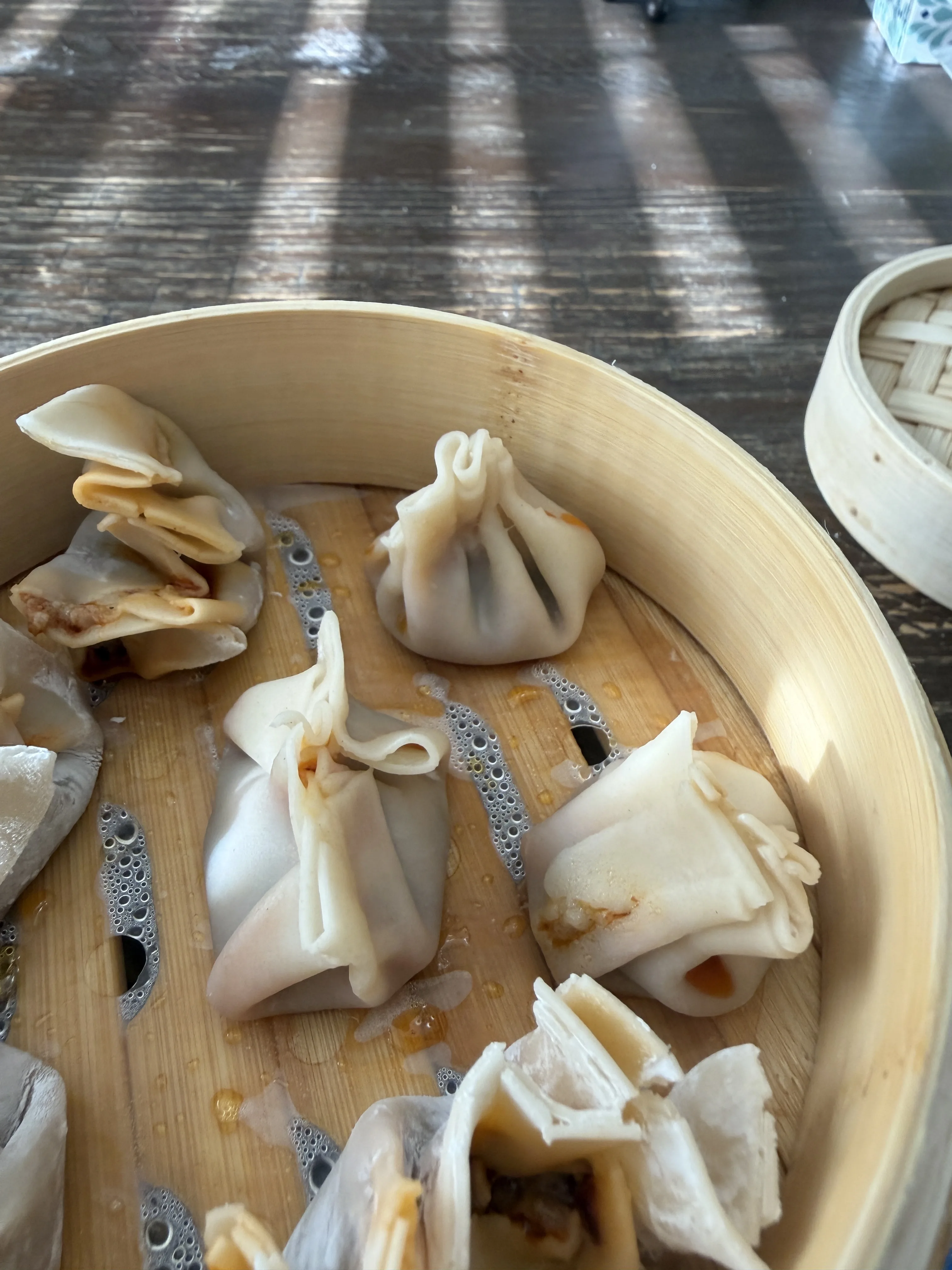 Close-up of pleated Chinese steamed dumplings in a bamboo basket