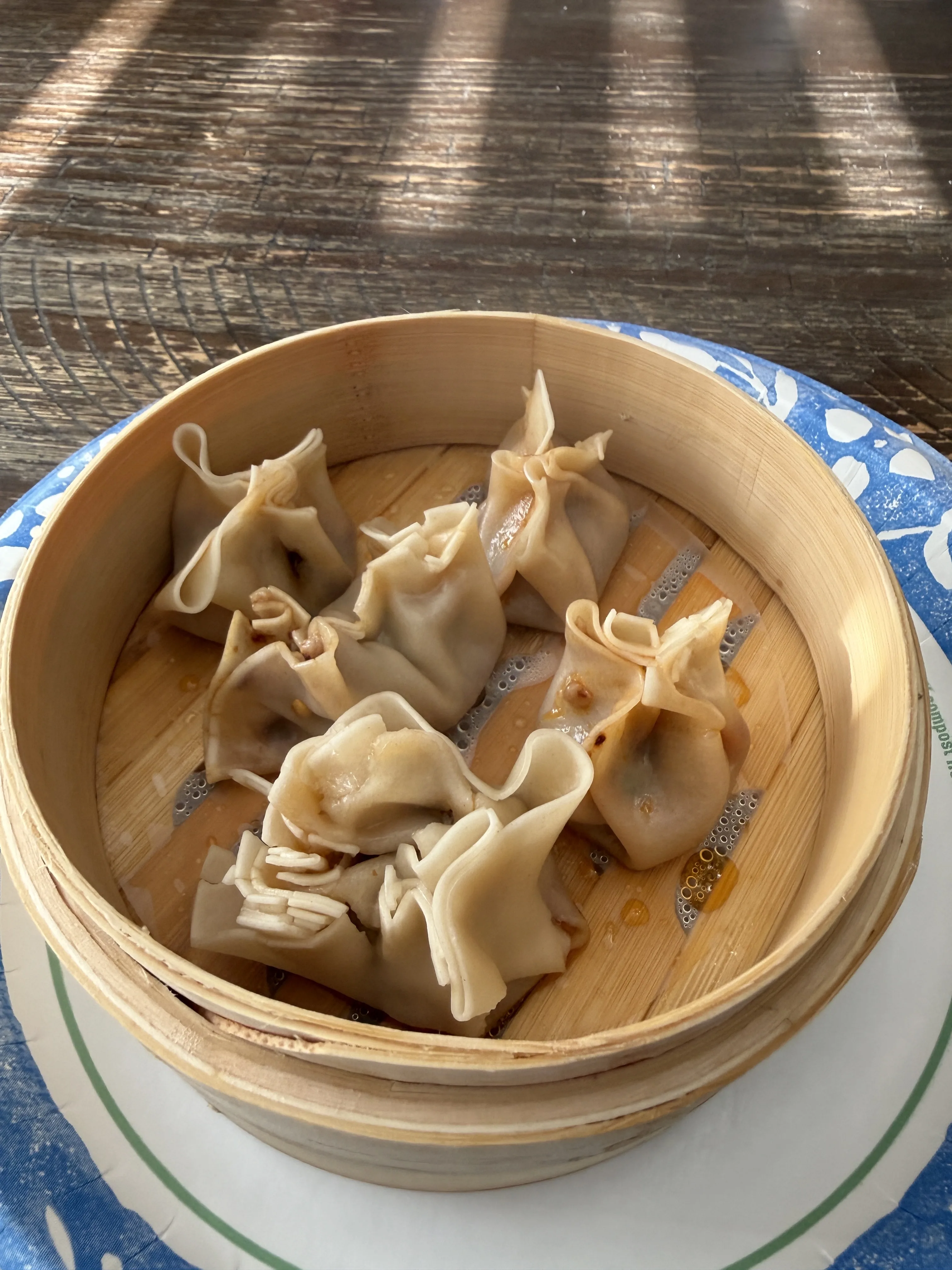A bamboo steamer full of finished Chinese steamed pork and chive dumplings