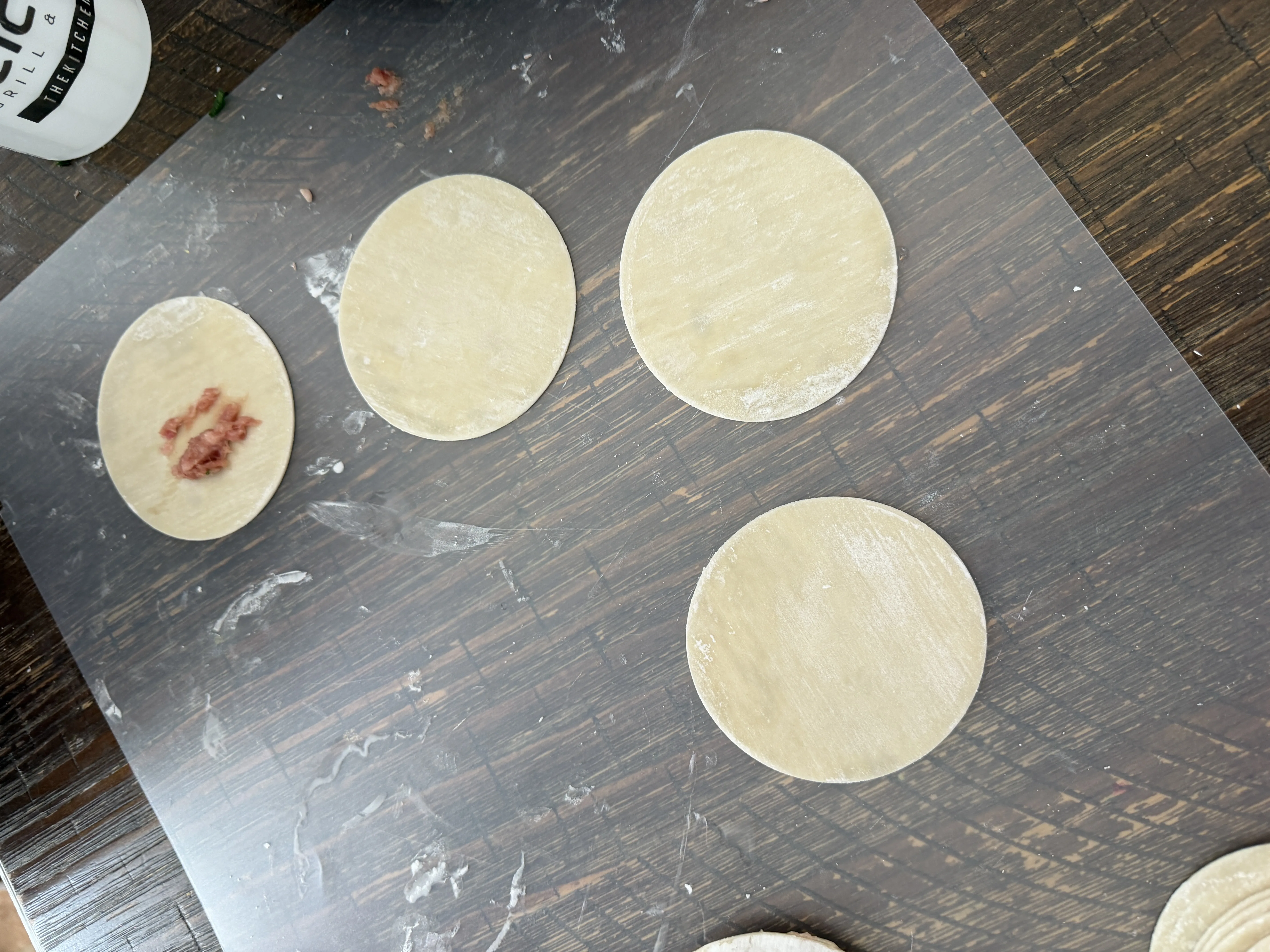 Round dumpling wrappers laid out on a cutting board ready to be filled