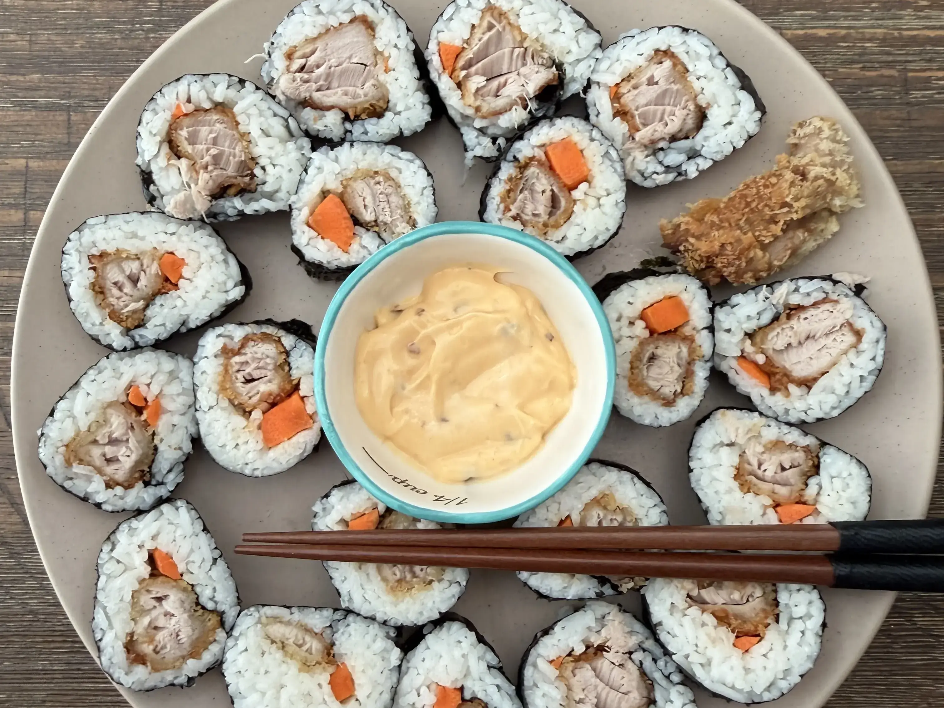 Fresh caught tuna tempura rolls arranged on a plate with spicy mayo dipping sauce and chopsticks