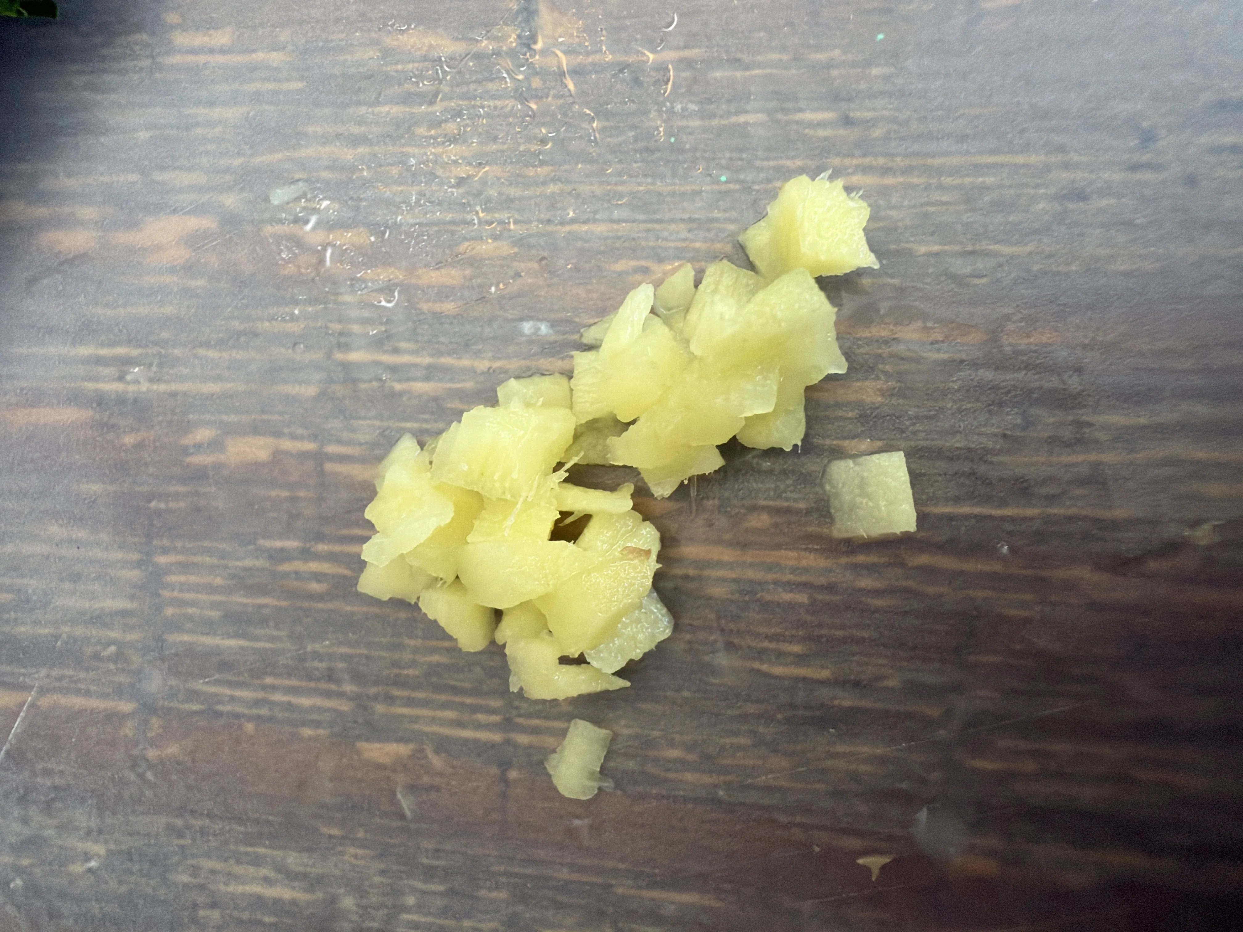Finely minced fresh ginger on a wooden cutting board