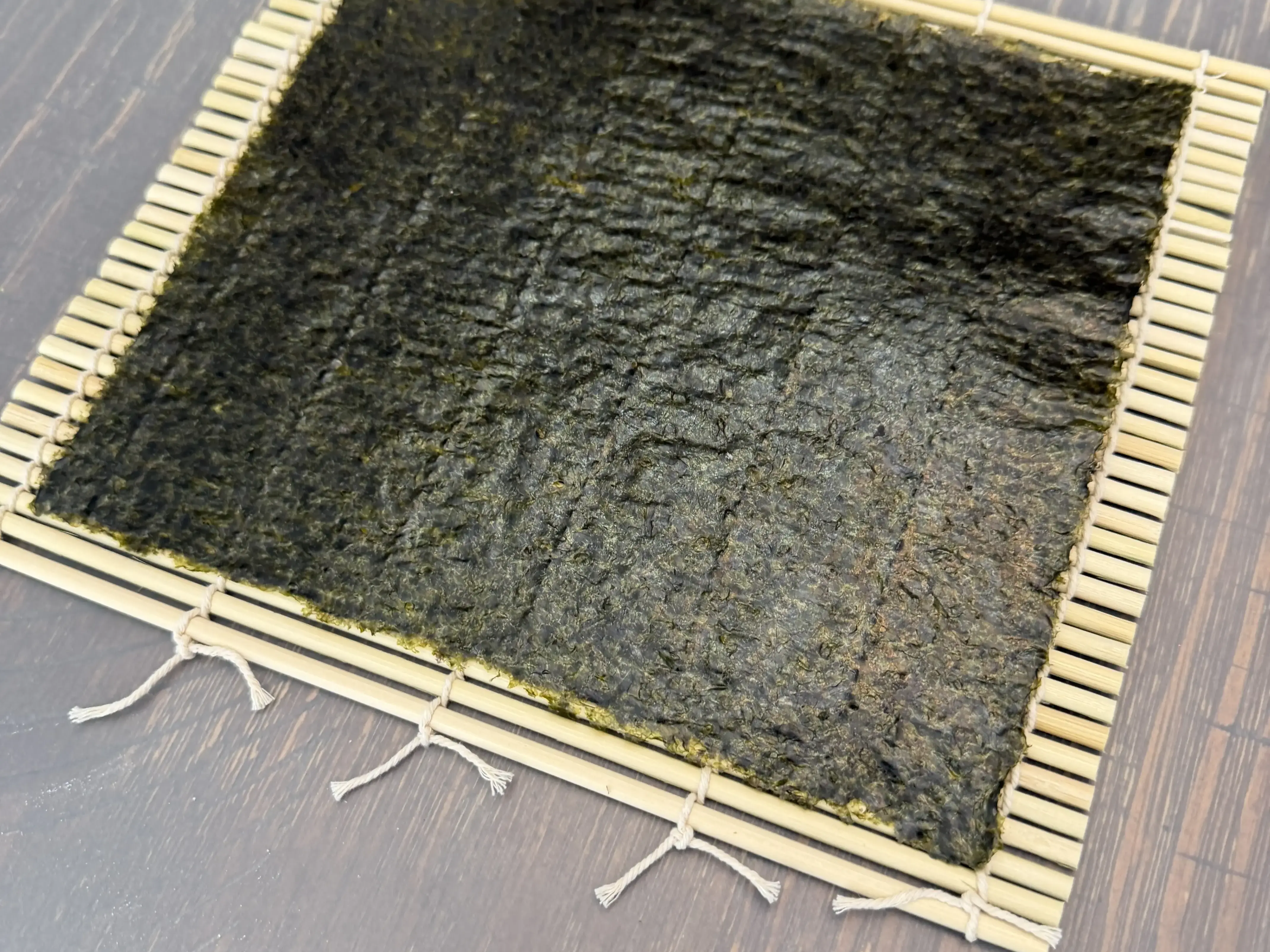 Nori sheet on bamboo rolling mat ready for sushi